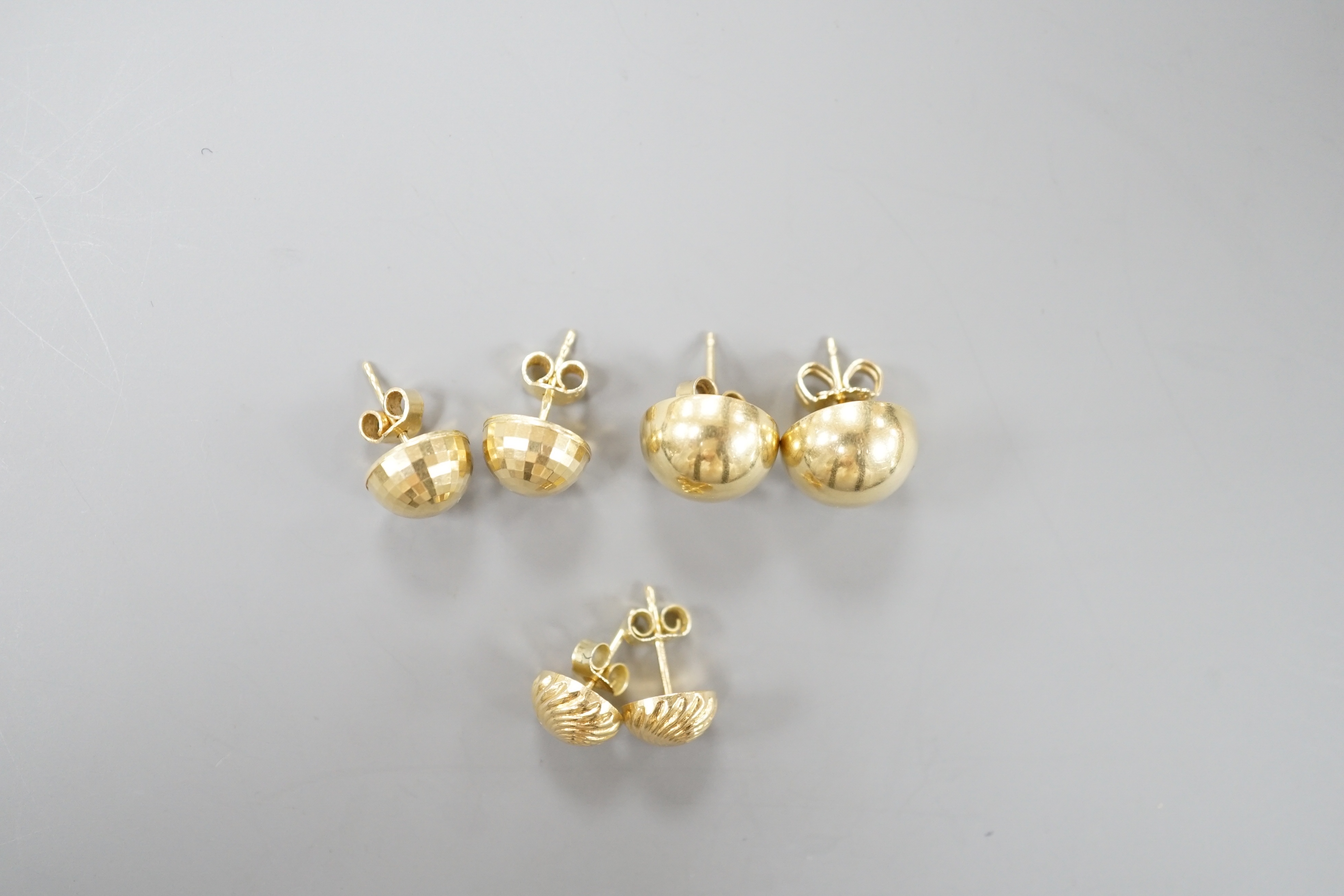 Two modern pairs of 750 yellow metal ear studs, one with 925 butterflies, gross 7.3 grams and a pair of 585 ear studs 2.3 grams.